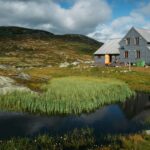rural-cottage-house-on-field-with-green-grass-and-small-pond-norway-hardangervidda-national-park.jpg